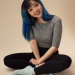 Photo of Minnie Ng sitting cross-legged on the floor
