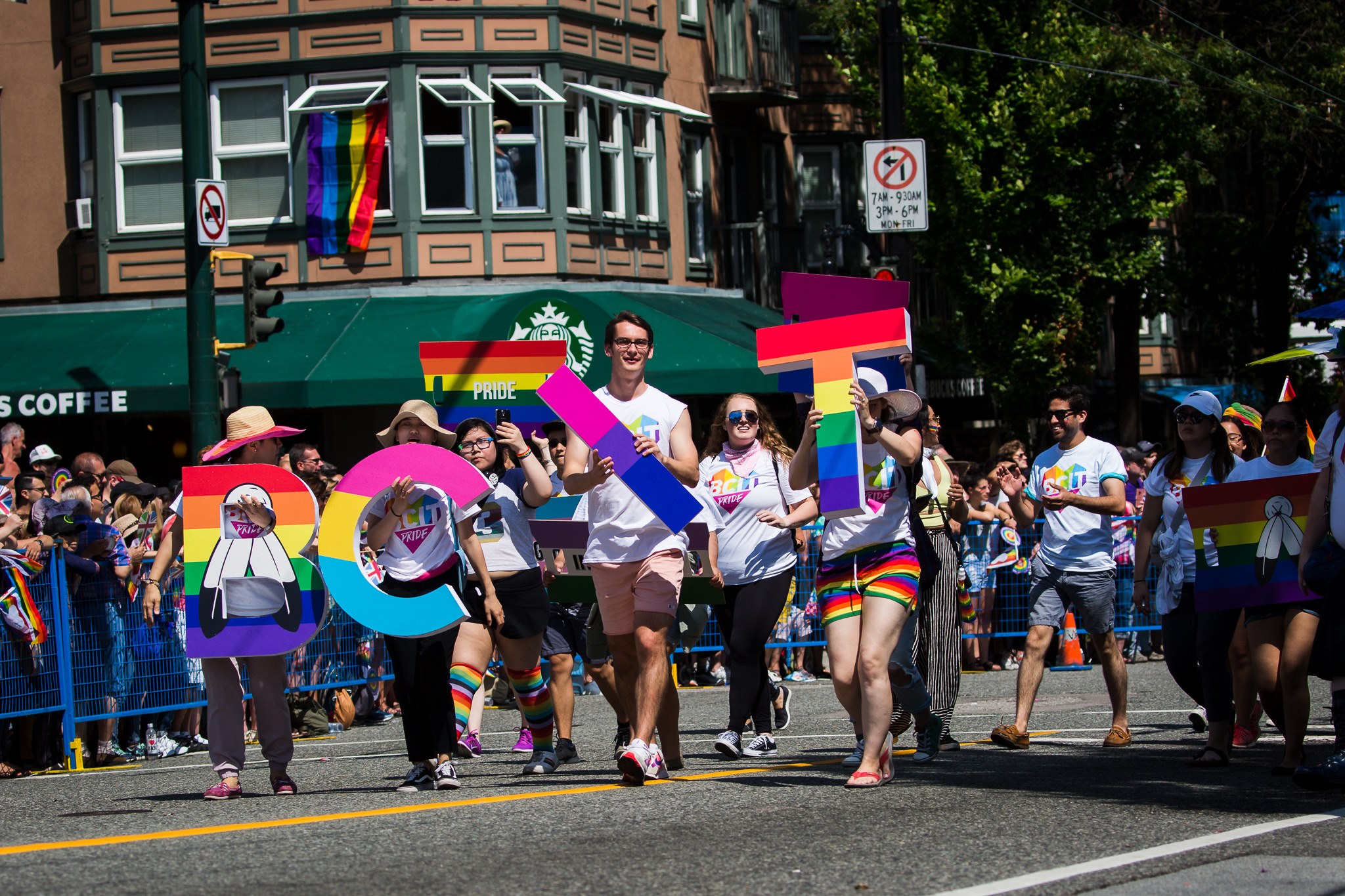 Photo from BCIT pride parade of a group of people holding up the letters BCIT with rainbow design