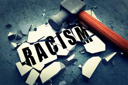 Picture of a hammer on a broken tile with the word 'racism'