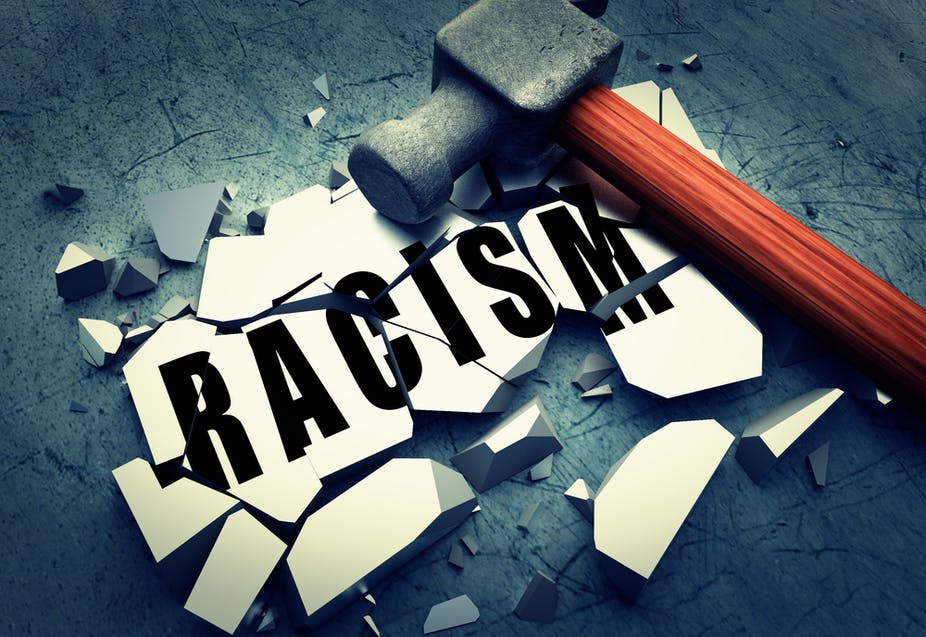 Picture of a hammer on a broken tile with the word 'racism'