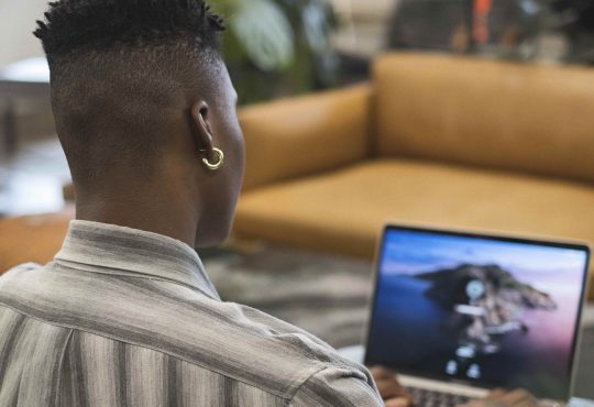 A non-binary person using a laptop at work