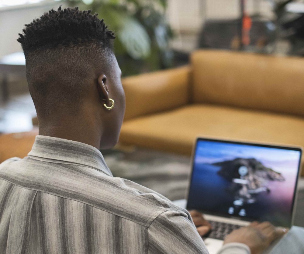 A non-binary person using a laptop at work