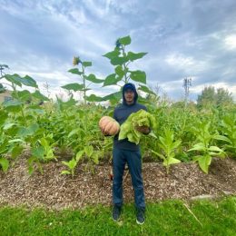 Picture of a person in a field holding a squash
